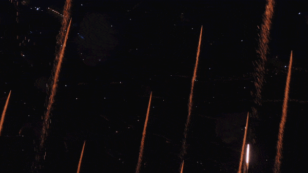 Colorful fireworks shooting into a dark night sky